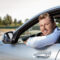 Cheerful,Man,Is,Sitting,At,Steering,Wheel,Near,Airport.,He